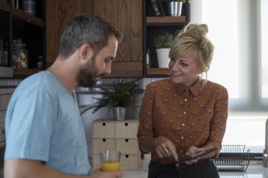 Sabah mutfakta bir çift. Tablette bir şey izlerken eğleniyorlar..