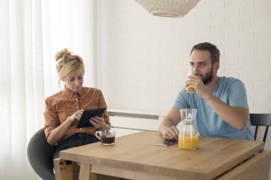 Masanın yanında oturan bir çift. Tablette bir şeyi tartışıyorlar..