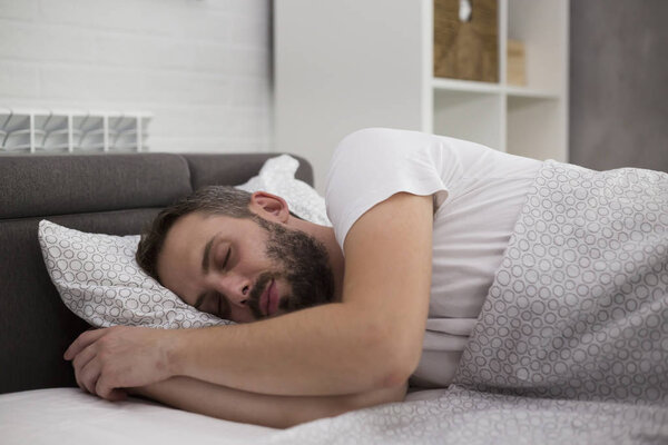 Мужчина спит в своей спальне
.