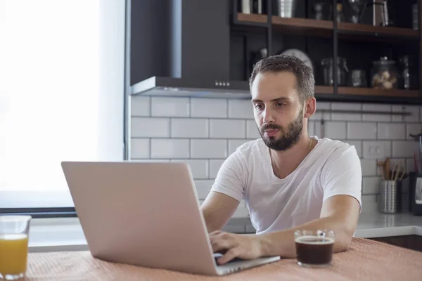 Fokuserad ung man som arbetar på småföretag startar med en bärbar dator. — Stockfoto