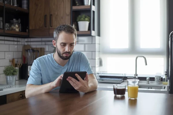 Fokuserad ung man som arbetar på småföretag startar med en surfplatta. — Stockfoto