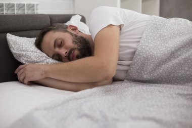 Yatak odasında uyuyan adam