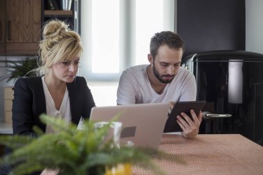 Sabah mutfakta bir çift. Onlar tablet ve dizüstü bilgisayar üzerinde çalışıyoruz.