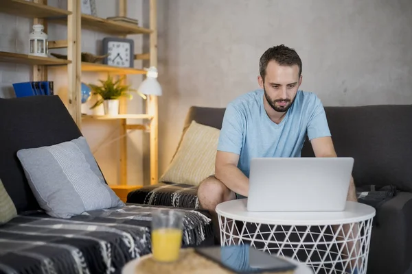 Ung man surfar på laptop. — Stockfoto