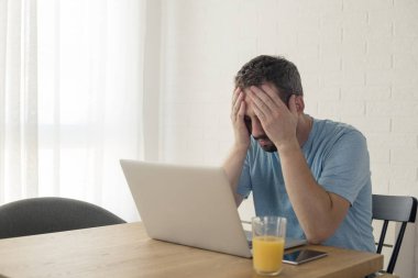 Genç adam dizüstü bilgisayar üzerinde çalışırken hayal kırıklığına uğradı.