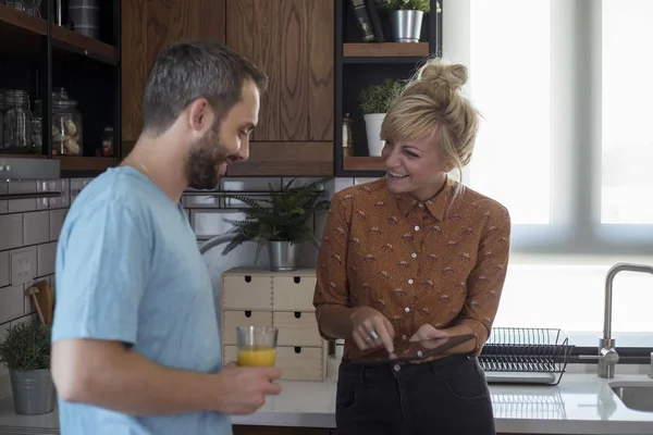 Sabah mutfakta bir çift. Tablette bir şey izlerken eğleniyorlar..