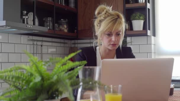 Zdemaskowane Młoda Kobieta Patrząc Laptopa Ona Siedzi Jej Stole Kuchni — Wideo stockowe