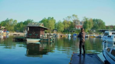 Nehir denizinde balık tutan uzun kahverengi saçlı adam.