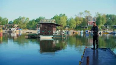 Nehir denizinde balık tutan uzun kahverengi saçlı adam.