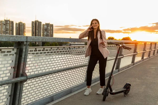 Egy Fiatal Mosolygós Lány Áll Hídkerítésnél Miközben Telefonál Mellette Egy — Stock Fotó