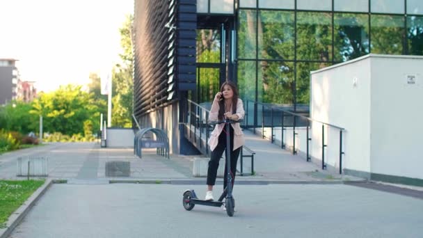 Młoda Piękna Kobieta Stojąca Obok Skutera Elektrycznego Podczas Korzystania Telefonu — Wideo stockowe