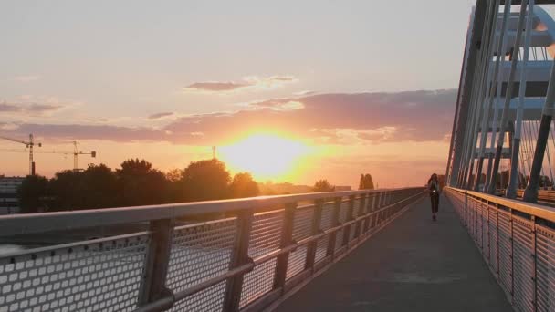 一个年轻漂亮的女人正骑着她的电动车过桥 她受过商业训练 面带微笑 背景包括一座现代桥梁的各个部分 — 图库视频影像