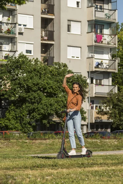 Jonge Mooie Vrouw Rijdt Een Elektrische Scooter Door Een Stedelijke — Stockfoto