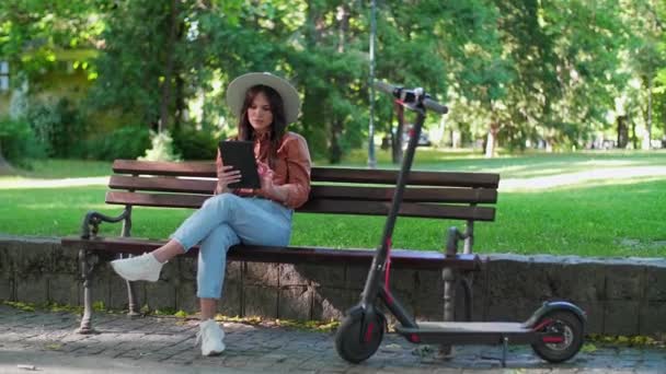 Een Jonge Vrouw Met Een Hoed Zit Een Bankje Het — Stockvideo