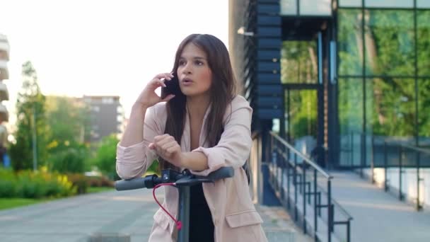 Eine Junge Schöne Frau Steht Neben Einem Elektroroller Während Sie — Stockvideo