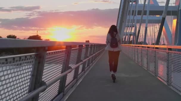 Młoda Piękna Kobieta Jeździ Skuterze Elektrycznym Przez Most Jest Wyszkolona — Wideo stockowe