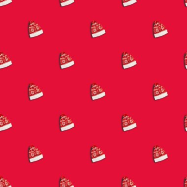 Kırmızı arka planda geyikler olan kırmızı bir Noel şapkası, kusursuz desenli. Noel Baba şapkası