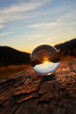 İspanya 'nın güneyindeki Asturias dağlarında günbatımında bir kristal küre her şeyi dikey ahşap bir bankın tepesinde döndürür.