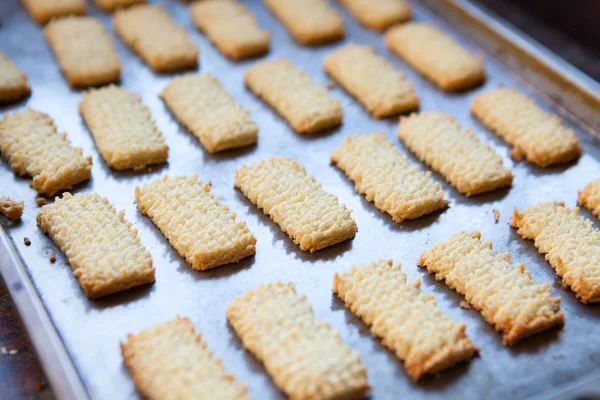 Freshly baked biscuits on metal baking tray — Stock Photo, Image