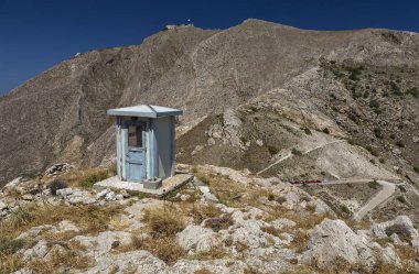 Yunanistan'ın Santorini adasında bir dağın tepesinde Thera Antik Köyü'nün girişine kadar giden dolambaçlı yol.
