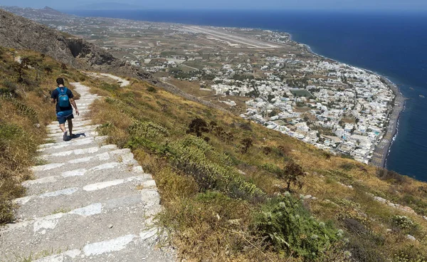 Wioska Kamari na wyspie Santorini w Grecji, widziana z drogi powyżej przy wejściu do starożytnej wioski Thera w jasnym, słonecznym dniu. — Zdjęcie stockowe