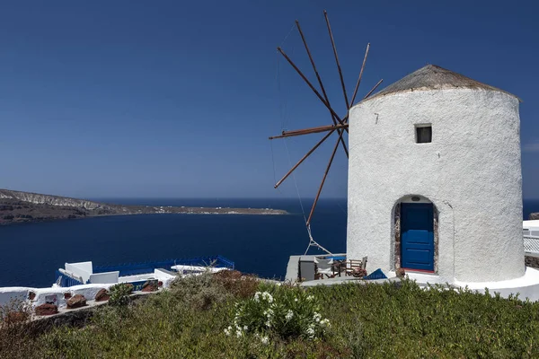 Molino de viento en el pueblo de Oia en la isla de Santorini, Grecia. — Foto de Stock