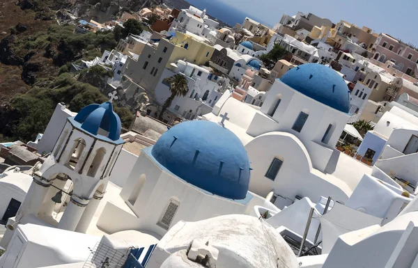 Traditionell grekisk vit kyrka båge med kors och klockor i byn Oia av Kykladerna ön Santorini Grekland. — Stockfoto