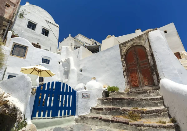 Ein typisches haus in der stadt oia in santorini, griechenland mit stuck und steinmauern. — Stockfoto