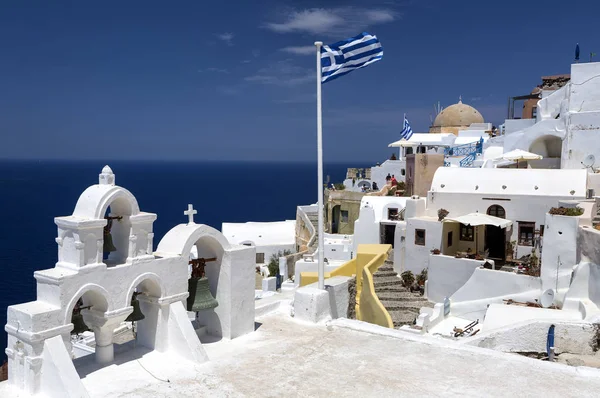 Greek flag and four bells in Oia, Santorini, Greece.