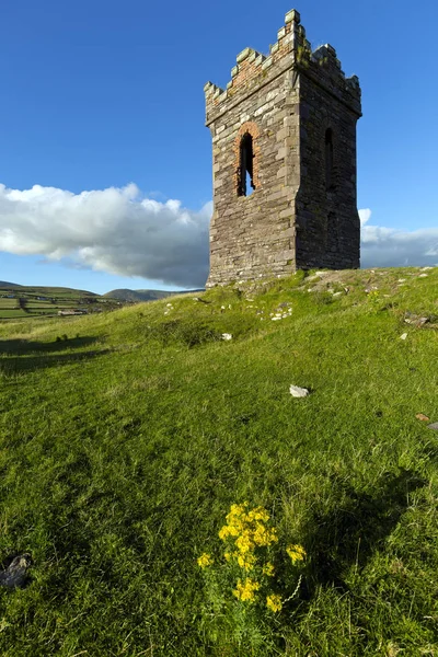 Een oude stenen uitkijktoren met uitzicht op Dingle Bay Co. Kerry Ierland als een vissersboot gaat naar zee. — Stockfoto