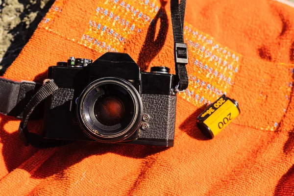 Old Unrecognizable Black Analog Photo Camera Orange Background 35Mm Reel — Stock Photo, Image