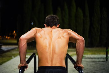 Gece antrenmanında üstsüz, kaslı genç adam eğitimi. Halka açık bir bar parkında. Daldırıyorum. Görüntü Yönetmeni:.