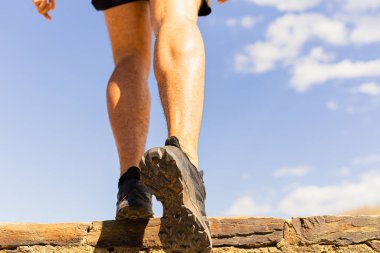 Tanınmayan genç bir sporcunun bacakları güneşli bir günde merdivenlerden çıkarken spor ayakkabıları. Arkadan ve aşağıdan görüntüler.