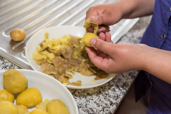 Mutfakta, taze pişmiş patates kabuğu kaldırılır