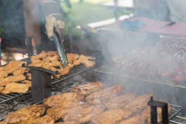 Kişi biftek ve sosis ızgara ızgara üzerinde ızgara maşa ile döner