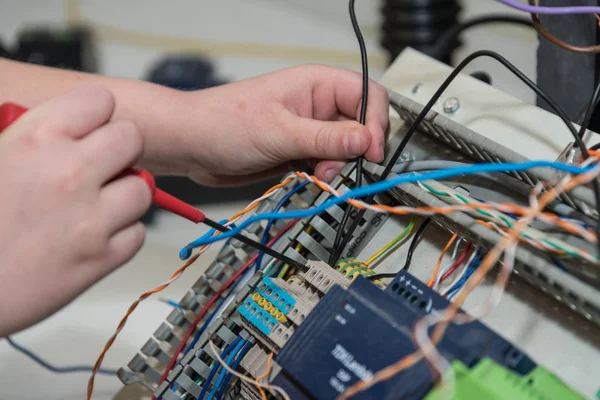 Electrical engineer works with screwdriver on installations in the workplace - closeup