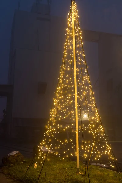 large LED string light lit Christmas tree as an outdoor decoration - Christmas tree