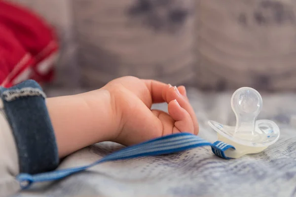 Baby hand en een fopspeen - close-up — Stockfoto