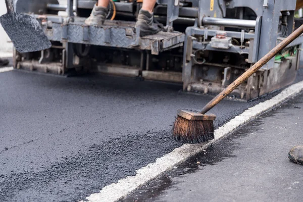 Asfaltlama işi - süpürge ile inşaat işçisi