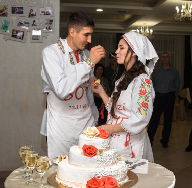 Gelin ve damat Milli giysileri birbirine bir pasta düğün ile besleme.