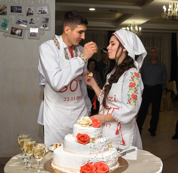 Gelin ve damat Milli giysileri birbirine bir pasta düğün ile besleme.