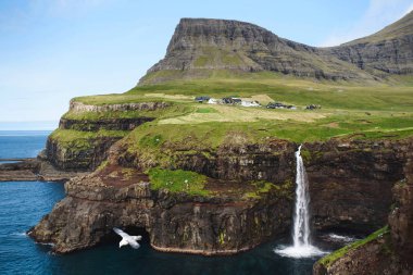 Deniz kıyısı, şelale ile güzel dağ kayalıklarla