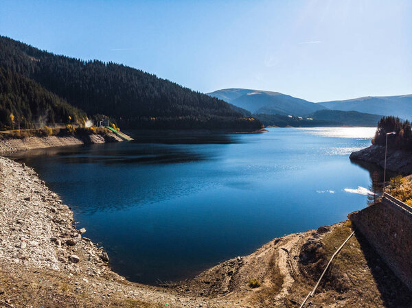 aerial view of blue lake water at pine forest in mountains