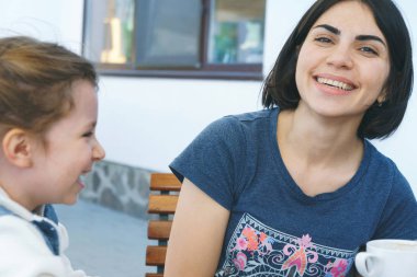 Anne ve kızı bahçesinde oturan gülüyor