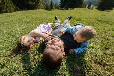 Baba ve çim döşeme ve oynayan çocuklar