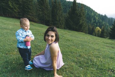 küçük oğlu ile orman yeşil çimenlerin üzerinde rahatlatıcı kadın 