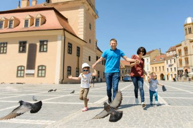 mutlu aile uçan güvercinler ile sokakta çalışan