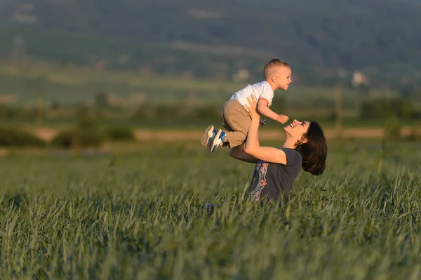 Ridendo Madre Tenendo Figlio Armi Nel Campo Erba — Foto Stock