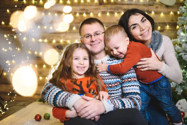 Famiglia Sorridente Seduta Insieme Nella Casa Natale Con Ghirlanda Illuminata — Foto Stock