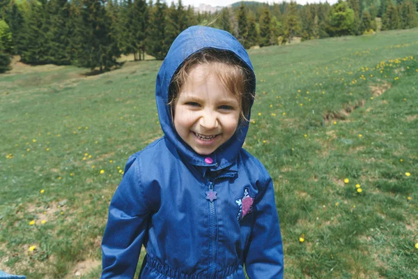 Rindo Menina Casaco Azul Capuz Prado Ensolarado — Fotografia de Stock